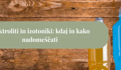 Dve plastenki izotoničnega napitka različnih barv, postavljeni na leseno podlago kot naslovna slika članka o elektrolitih.