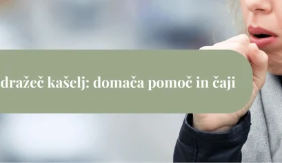 Ženska v šalu in plašču si pokriva usta med suhim kašljem; ozadje je mehko zamegljeno.